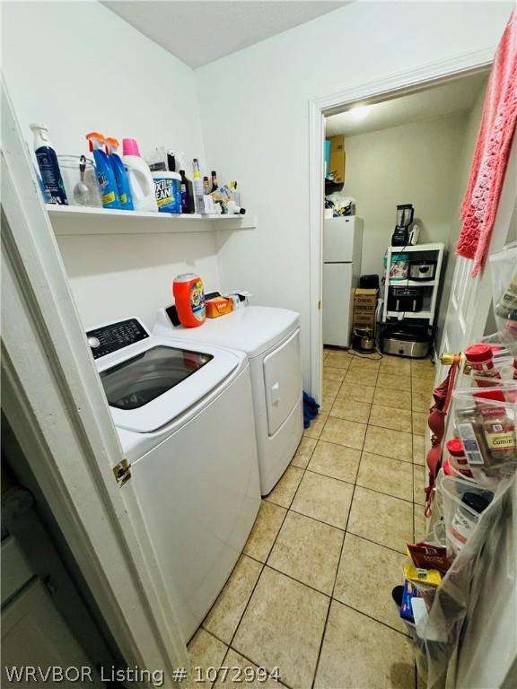 laundry room featuring independent washer and dryer and light tile patterned flooring