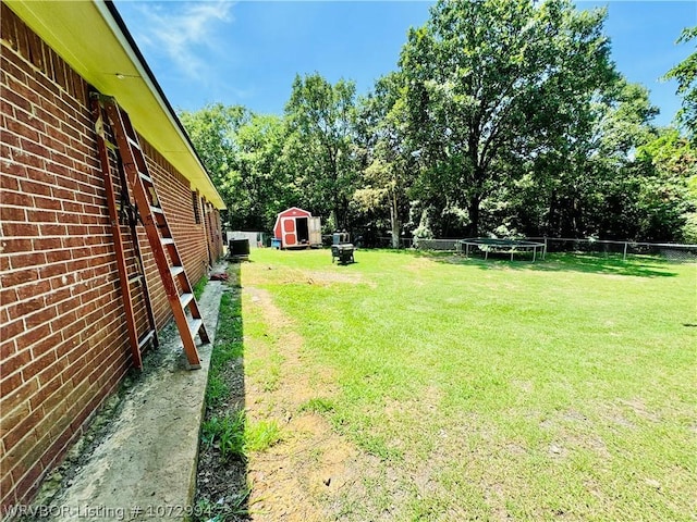 view of yard with a storage unit and a trampoline