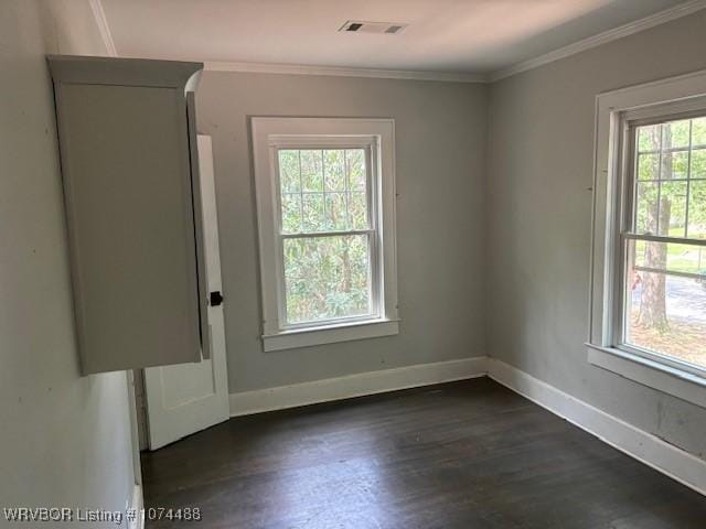 spare room featuring dark hardwood / wood-style flooring and crown molding