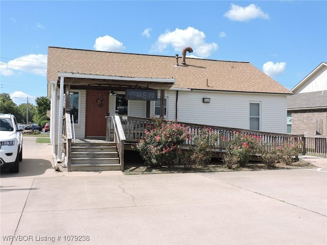 view of front of home with covered porch and roof with shingles