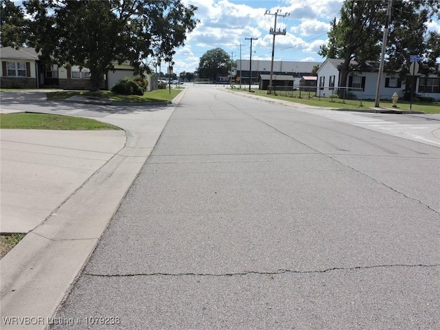 view of road featuring traffic signs and curbs