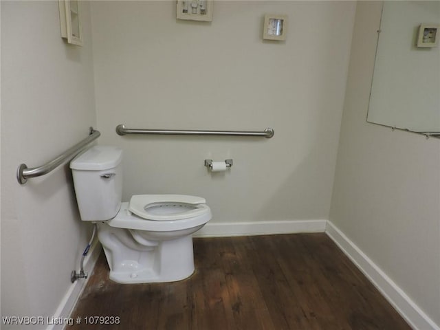 bathroom with toilet, baseboards, and wood finished floors