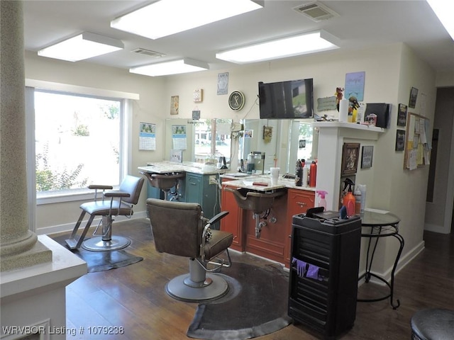 interior space featuring ornate columns, baseboards, visible vents, and wood finished floors