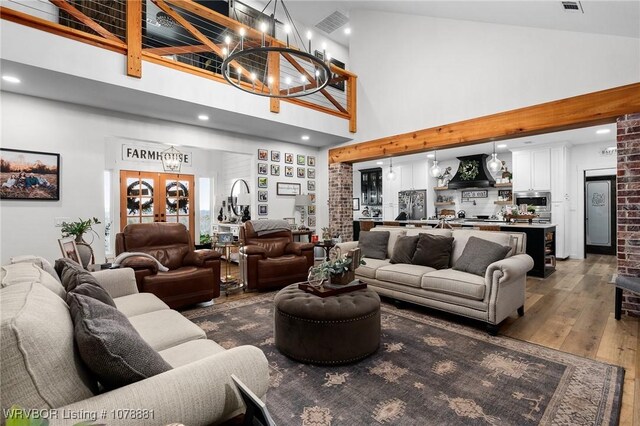 kitchen with premium range hood, white cabinets, hanging light fixtures, stainless steel appliances, and a barn door