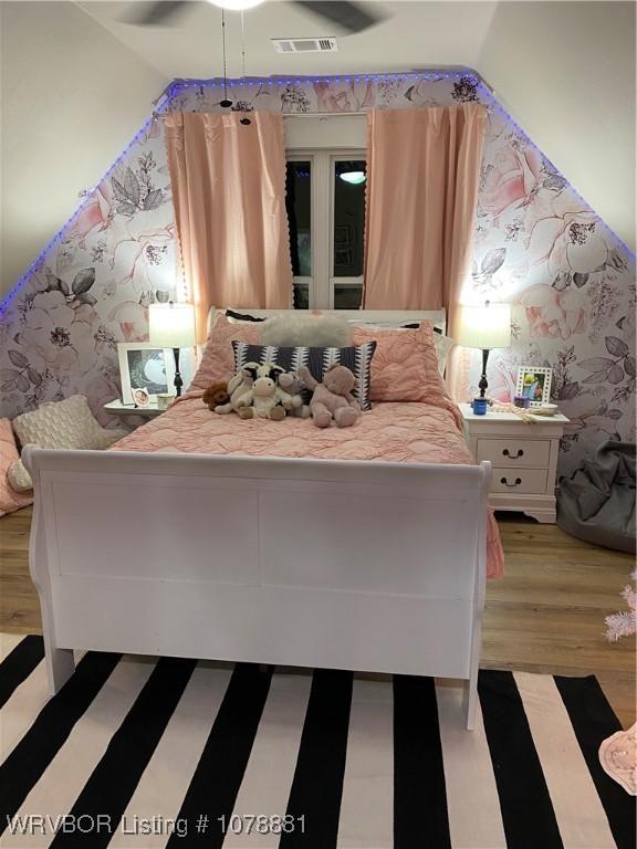 unfurnished bedroom featuring vaulted ceiling and light wood-type flooring