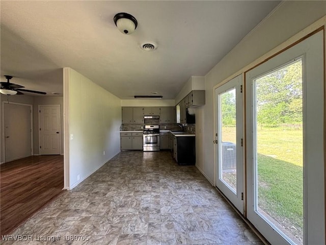 kitchen with baseboards, light countertops, a ceiling fan, gas stove, and gray cabinetry