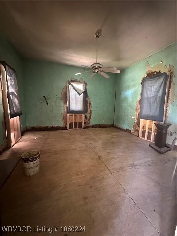 interior space with concrete floors and a ceiling fan