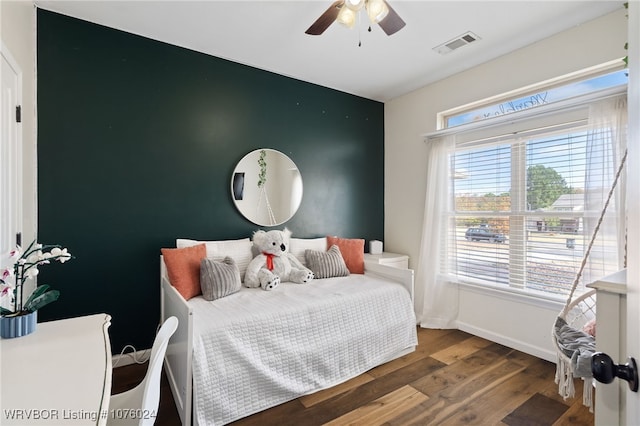 bedroom with ceiling fan, dark wood-type flooring, and multiple windows