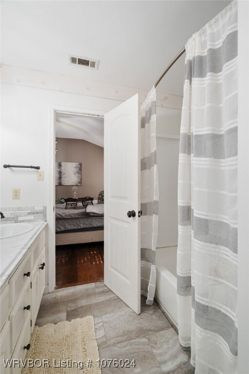 bathroom featuring vanity and shower / bath combo