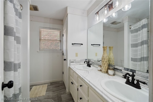 bathroom featuring vanity and backsplash