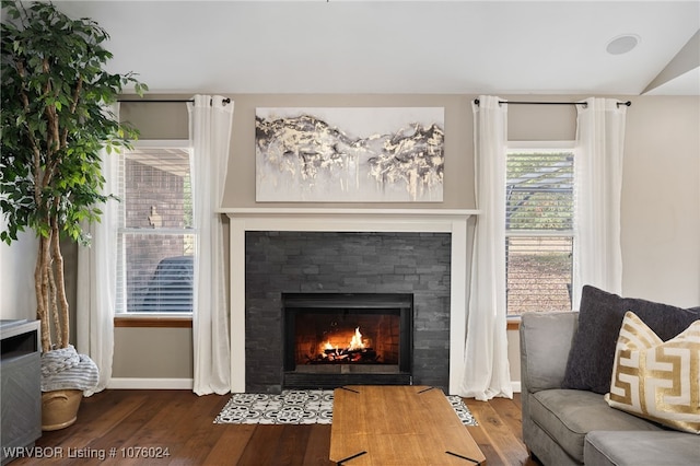 living room with a tile fireplace, hardwood / wood-style floors, and lofted ceiling