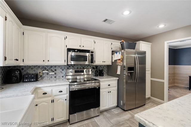 kitchen featuring sink, white cabinetry, stainless steel appliances, and tasteful backsplash