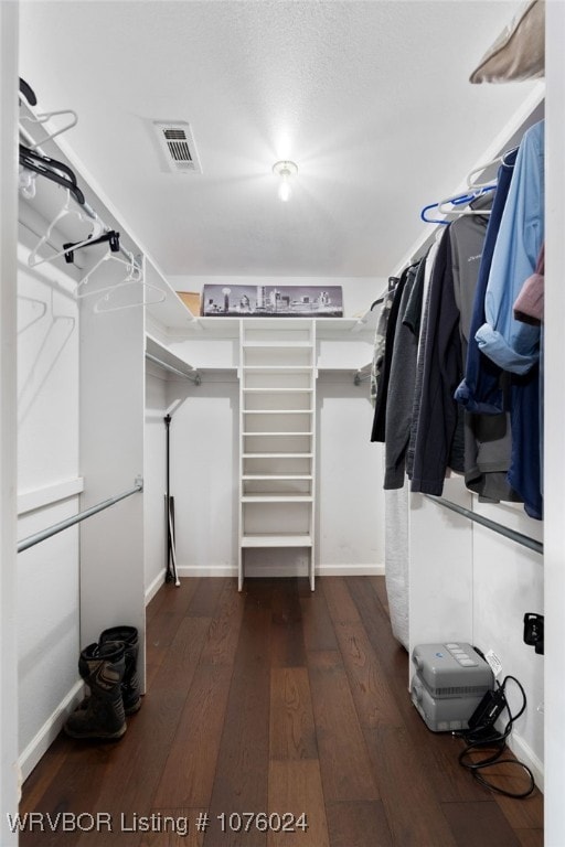 spacious closet with dark hardwood / wood-style floors