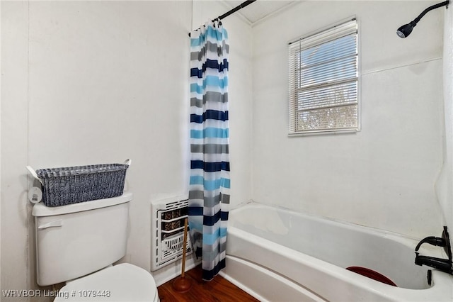 full bathroom featuring wood finished floors, toilet, heating unit, and shower / bath combo with shower curtain