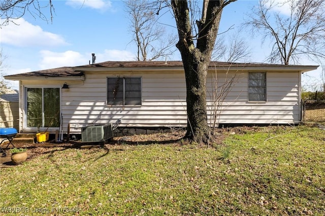 rear view of house featuring a yard and central AC unit