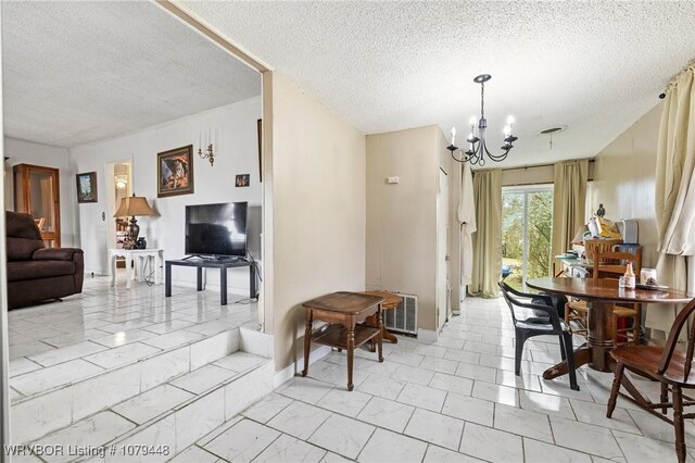 dining area with marble finish floor, visible vents, a textured ceiling, a chandelier, and baseboards