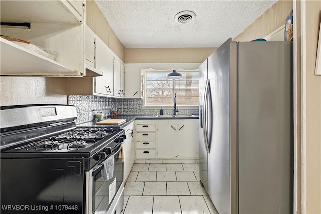 kitchen with stainless steel appliances, a sink, visible vents, white cabinets, and dark countertops