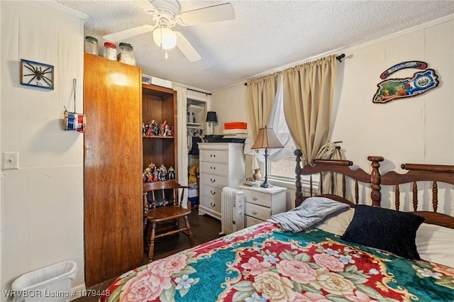 bedroom with radiator heating unit, a ceiling fan, and a textured ceiling