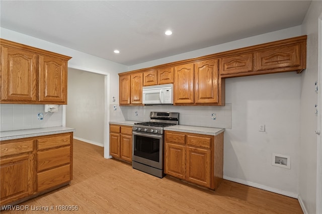 813 Melba Denton Ln, Sallisaw, OK 74955 - kitchen featuring white microwave, stainless steel gas range oven, brown cabinets, backsplash, and recessed lighting