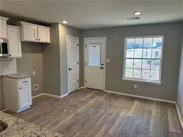 kitchen featuring visible vents, white cabinets, and wood finished floors