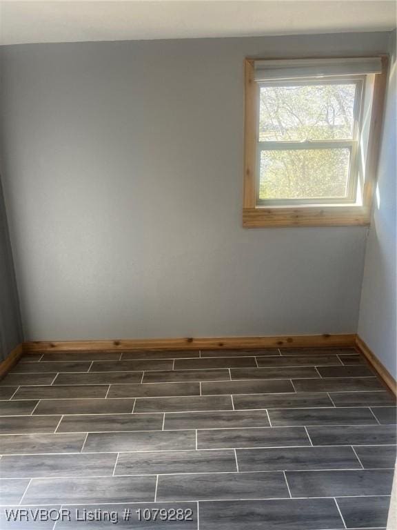 empty room featuring baseboards and wood tiled floor