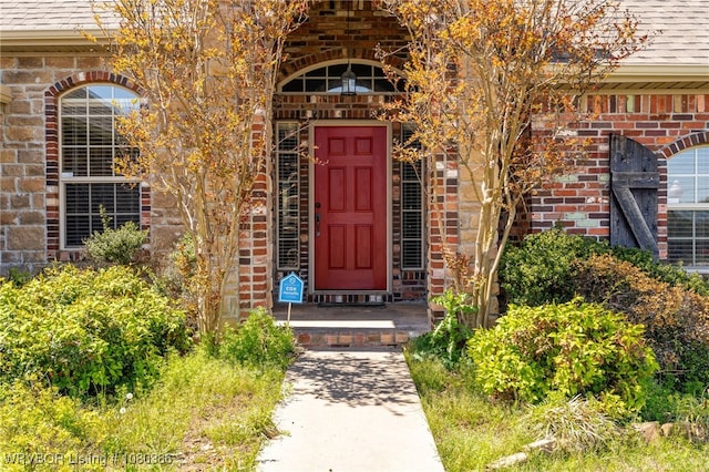 doorway to property featuring brick siding