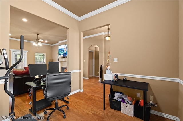 office area with a ceiling fan, wood finished floors, arched walkways, and ornamental molding