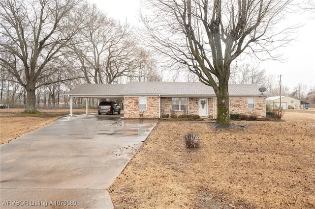 ranch-style house with a carport, concrete driveway, and brick siding