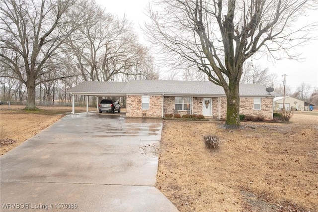 ranch-style house with driveway, an attached carport, and brick siding