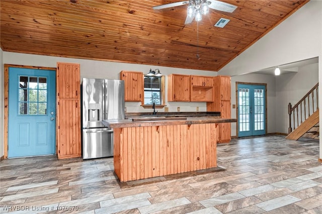 kitchen featuring a healthy amount of sunlight, stainless steel fridge with ice dispenser, and vaulted ceiling