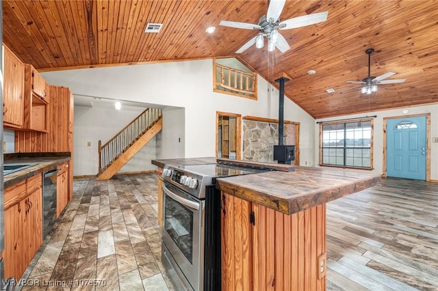 kitchen featuring vaulted ceiling, a wood stove, wood ceiling, and stainless steel electric range