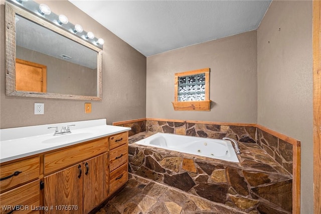 bathroom with vanity and tiled tub