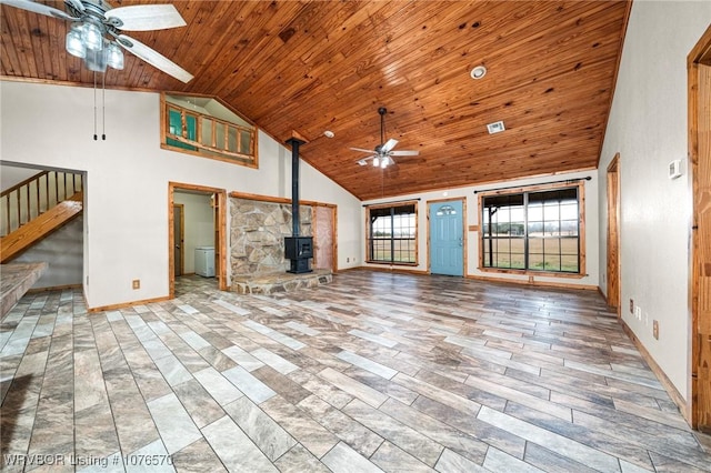 unfurnished living room featuring ceiling fan, a wood stove, high vaulted ceiling, and wooden ceiling