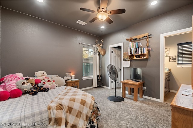 carpeted bedroom featuring ensuite bath and ceiling fan