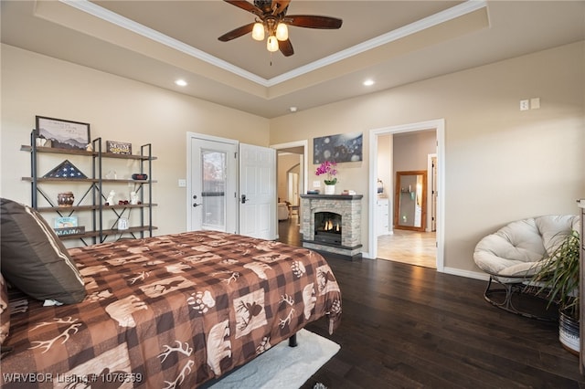 bedroom featuring a raised ceiling, ceiling fan, ensuite bathroom, and hardwood / wood-style flooring