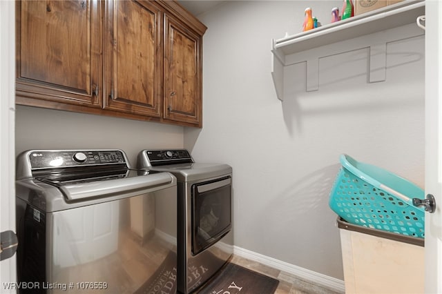 laundry area featuring washer and clothes dryer and cabinets