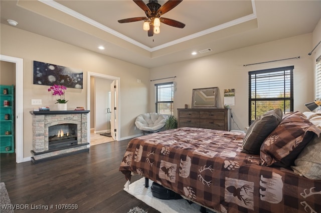 bedroom with multiple windows, a tray ceiling, and ceiling fan