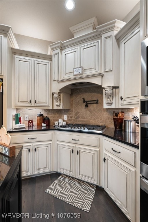 kitchen with stainless steel gas stovetop, dark hardwood / wood-style flooring, white cabinetry, and tasteful backsplash