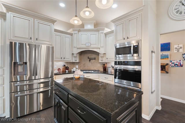 kitchen featuring dark stone counters, dark wood-type flooring, a center island, and stainless steel appliances