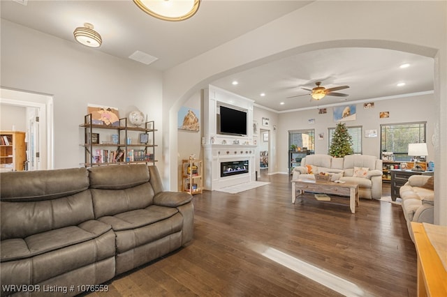 living room featuring ceiling fan, dark hardwood / wood-style flooring, and crown molding