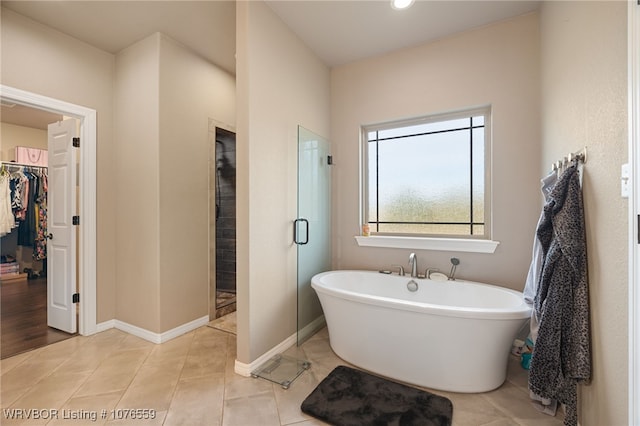 bathroom featuring tile patterned flooring and separate shower and tub