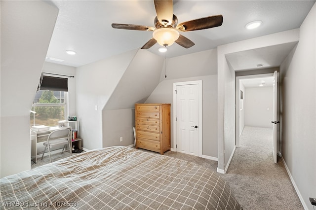 unfurnished bedroom featuring ceiling fan, light colored carpet, and vaulted ceiling