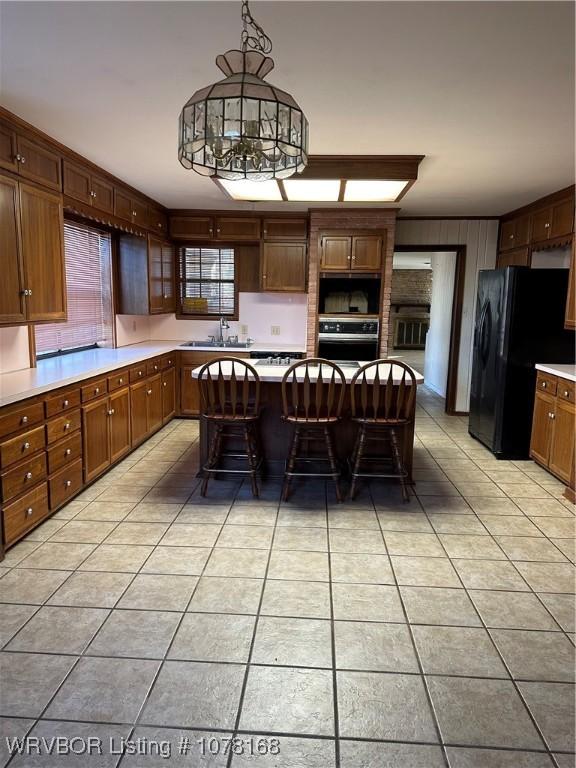 kitchen with pendant lighting, light tile patterned floors, oven, and a breakfast bar