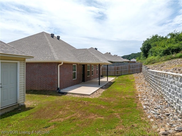 2325 Amy Ln, Van Buren, AR 72956 - rear view of house featuring a patio, brick siding, a shingled roof, and a fenced backyard