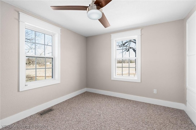 empty room featuring a ceiling fan, carpet, visible vents, and baseboards