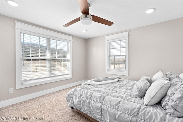 bedroom featuring multiple windows, carpet, and baseboards