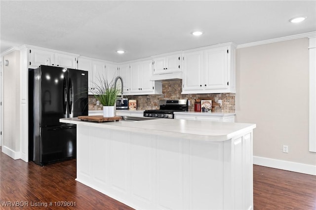 kitchen featuring stainless steel electric stove, freestanding refrigerator, decorative backsplash, light countertops, and white cabinetry