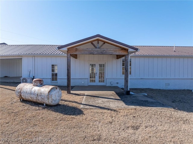 view of front facade featuring french doors, board and batten siding, and metal roof