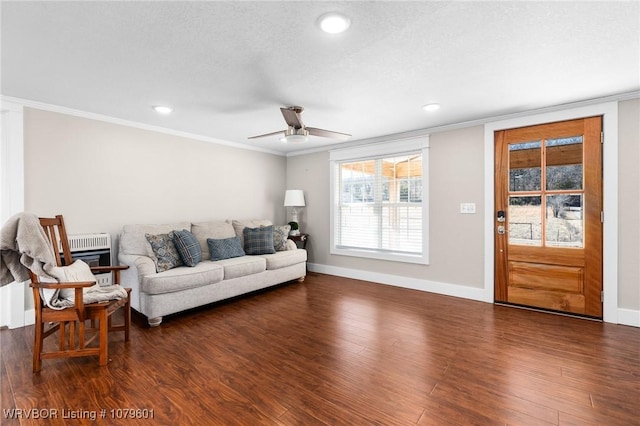 living room with dark wood-style floors, heating unit, crown molding, and ceiling fan