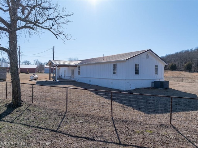 back of house with crawl space, cooling unit, metal roof, and fence